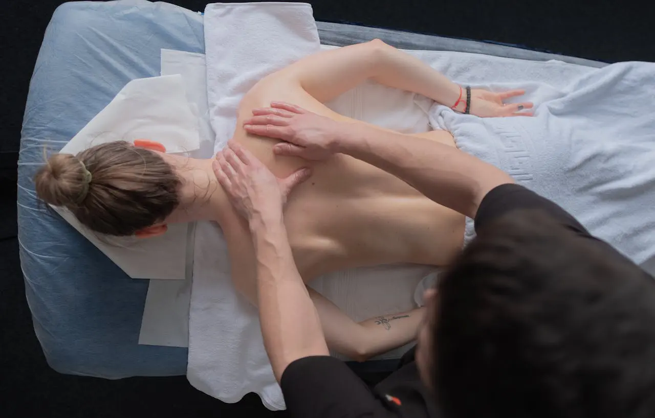 Professional massage therapist performing deep tissue back massage on a client in a spa setting